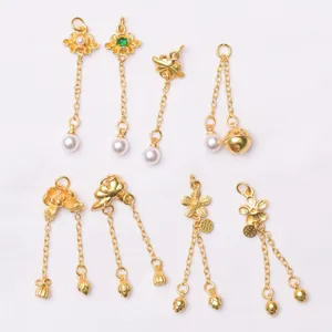 Detailed macro view of assorted ancient gold style charms with pearls and tassels