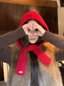 Detail of red knit balaclava scarf with thick weave texture and tie-up design