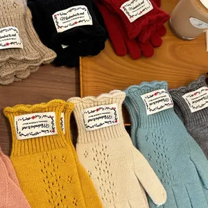 Flat lay of colorful lace hollow knit gloves in various autumnal shades on a tray