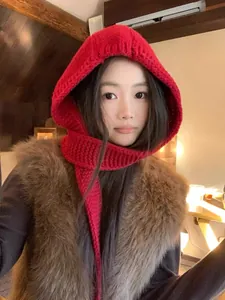 Close-up of bright red knitted balaclava showing thick textured wool and scarf detail