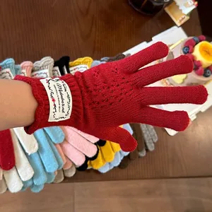 Detail view of heart-shaped hollow knit pattern on red winter fingerless wool gloves