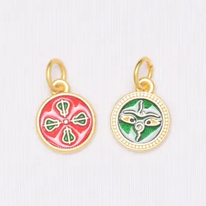 Detail of round enamel gold-plated charms with red floral and green Buddha eye patterns