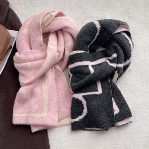 Thick knit winter scarf with geometric patterns in black and pink, soft cashmere feel