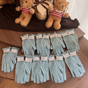 Detailed knit pattern on light blue fingerless gloves with elegant wavy scalloped edges