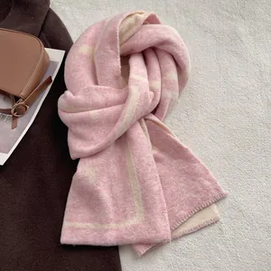 Detail view of pink and beige geometric knit pattern on thick faux cashmere scarf