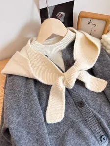 Detail of the knit texture and tied bow design on a soft winter balaclava hood