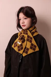 Detail of the 100% pure wool label on a yellow and brown argyle knit scarf