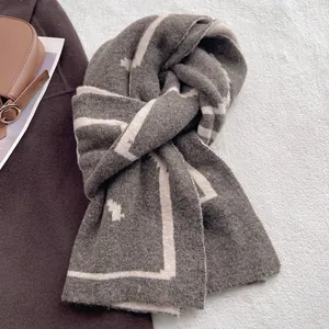 Detailed texture of thick geometric patterned knit scarf on a soft white surface