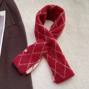 Détail macro d'une écharpe en maille bordeaux à motifs losanges avec étiquette tissée