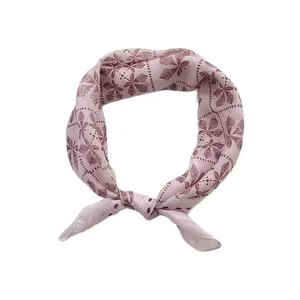 Foulard en coton rose avec motifs de feuilles rouge foncé noué en boucle sur blanc