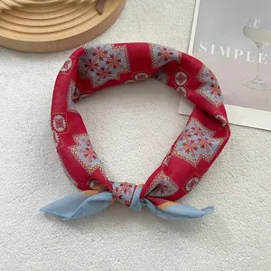 Detail eines Seidenschals mit rot-blauen geometrischen Mustern und Satin-Textur