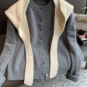 Detail of grey knitted cardigan with cream knit scarf and elegant button closure texture