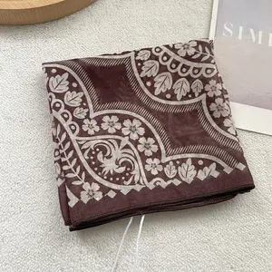 Vintage brown printed silk scarf with elegant floral patterns on soft textile