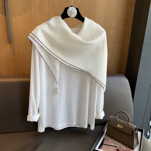 Detailansicht weißer Baumwollschal mit dunklem Rand und eleganten Fransen am Saum