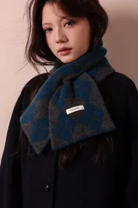 Detail shot of 100% pure wool label on a blue and grey argyle pattern knit scarf