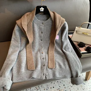 Detail of grey knitted cardigan with brown shawl showing fine ribbing and buttons