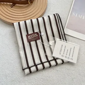 Écharpe en coton à rayures verticales minimalistes et châle chaud sur fond en peluche