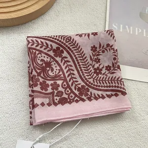 Detailed shot of pink paisley silk scarf with rolled edges and floral patterns
