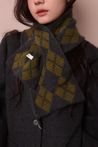Close-up of wool argyle knit scarf with green and grey patterns on a dark wool coat