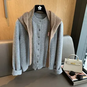 Detail view of grey knit cardigan with round neck buttons and camel shawl accessory