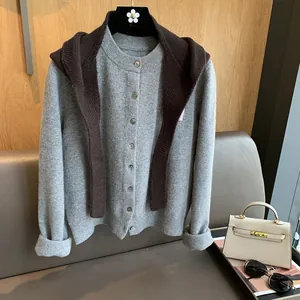 Detail of grey knitted cardigan and brown shawl featuring soft textured wool fabric