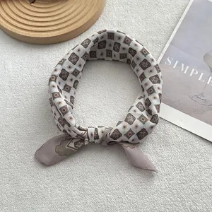 Détail d'un foulard noué en coton et lin avec motif jacquard géométrique beige