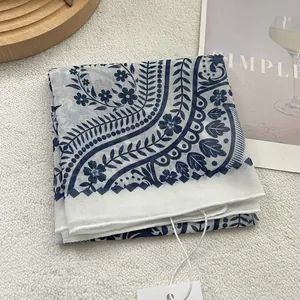 Detail of vintage blue floral print on lightweight white silk scarf with elegant pattern