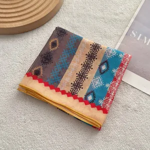 Detail of ethnic geometric print scarf with bohemian patterns and yellow stitched edges