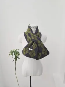 Detail of wool knit scarf with grey and yellow diamond pattern on white mannequin