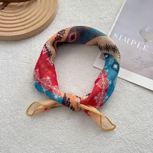 Detail of colorful geometric print silk scarf tied in a knot on a white texture background