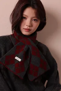 Close-up of 100% pure wool knitted scarf with classic grey and red diamond check pattern