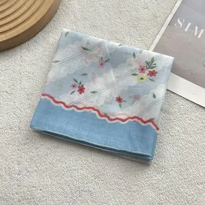 Light blue floral cotton linen square scarf with red wavy trim and delicate flower print