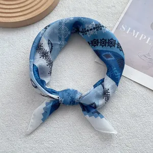Detail of blue and white geometric pattern scarf tied in a stylish ring knot