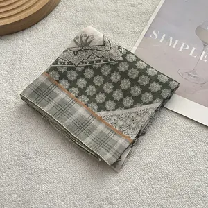 Dettaglio di un foulard retrò in cotone e lino piegato su uno sfondo minimalista