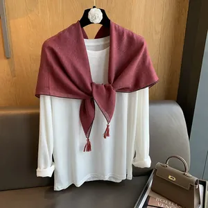 Detailansicht des weinroten Leinen-Mix-Schals mit Quasten über einem weißen T-Shirt