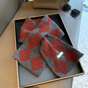 Detailed close-up of 100% wool knit scarf featuring red and grey argyle pattern texture