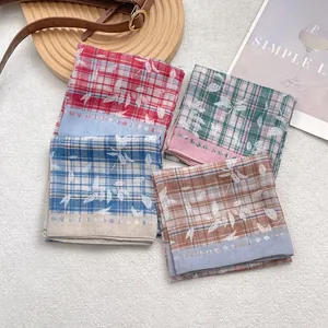 Set of four vintage plaid scarves with leaf prints on a stylish flat lay background