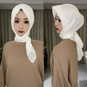 Détail du hijab blanc orné de strass argentés sur un tissu léger et respirant