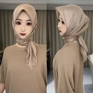 Détail des strass scintillants sur le hijab en lin de coton champagne avec plis