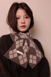 Detail of 100% pure wool scarf showing the argyle diamond pattern and material label