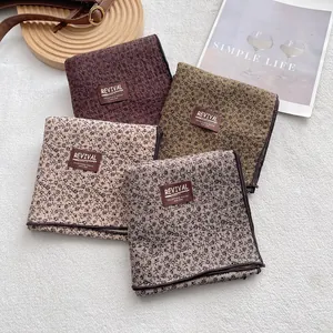 Floral cotton quilted scarves in coffee, olive, and apricot with leather brand patches