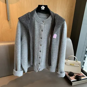 Close-up of dark grey knitted cardigan featuring a pink patch and dark buttons