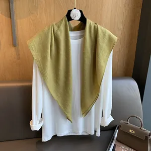 Élégant châle en lin vert moutarde orné de perles délicates sur un cintre noir