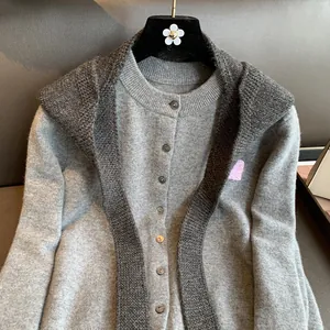 Detail of light gray knit cardigan with charcoal faux collar and metallic buttons