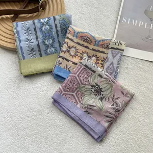 Three-piece set of thin cotton floral scarves in blue, yellow, and purple on a white rug