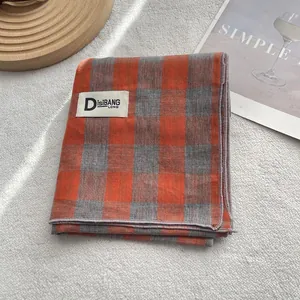 Long cotton scarf with orange and blue plaid pattern and elegant woven label