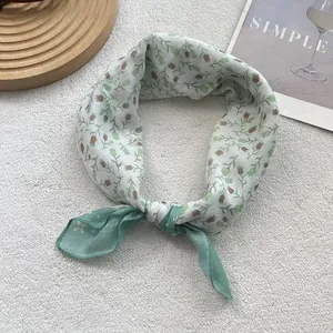 Close-up of cotton-linen small scarf featuring delicate tulip floral print and sea green patch