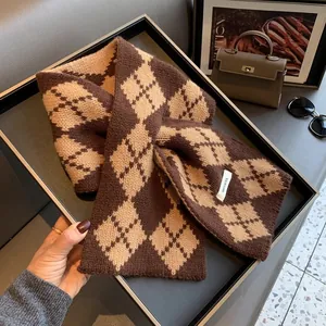 Macro detail of a 100% pure wool scarf featuring a brown and beige argyle knit pattern