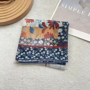 Close-up of vintage floral cotton linen scarf with fine stitched edges on white background