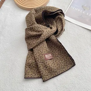 Detail of vintage brown floral scarf with REVIVAL brand label on textured fabric